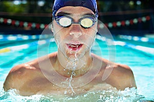 Athlete man, swimming pool and fitness with splash, speed or exercise for wellness, health or sport. Swimmer, closeup