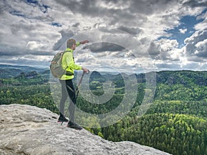 Athlete man tourist hiking mountain trail, walking on rock