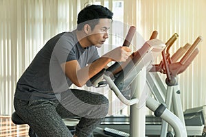 Athlete men, sport exercise concept. handsome man training on bicycle machine at gym in morning. People workout on machine