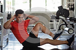 Athlete muscle man bicycle crunch in gym