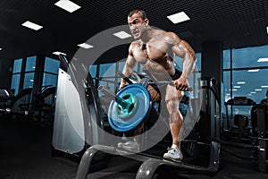 Athlete muscular bodybuilder in the gym training back