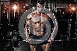 Athlete muscular bodybuilder in the gym training with bar