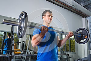 Athlete muscular bodybuilder in the gym training with bar