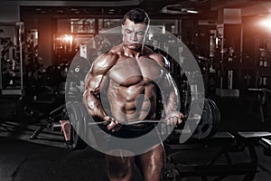 Athlete muscular bodybuilder in the gym training with bar photo