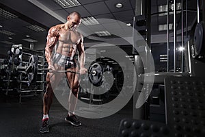 Athlete muscular bodybuilder training arms on simulator in the gym