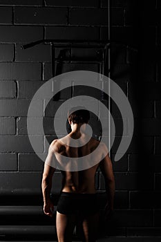 Athlete muscular fitness male model pulling up on horizontal bar