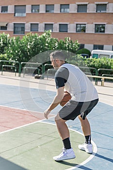 Athlete plays basketball very concentrated to keep track of his ball