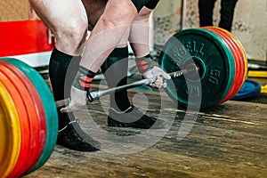 athlete powerlifter performing deadlift heavy barbell at powerlifting competition