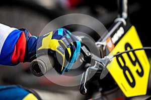 An athlete in a protective glove holds the handlebars