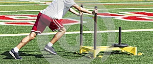 Athlete pushing weighted sled on turf field