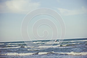 Athlete rides a sailing board at sea in a storm