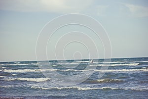 Athlete rides a sailing board at sea in a storm