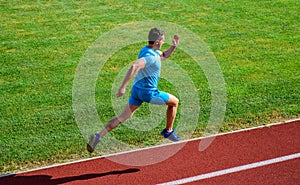 Athlete run track grass background. Sprinter training at stadium track. Runner captured in midair. Short distance