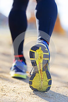 Athlete runner feet running in nature, closeup on shoe.
