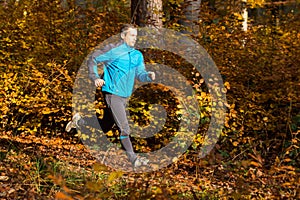 Athlete running in the forest in autumn