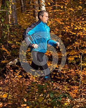Athlete running in the forest in autumn