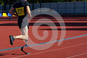 Athlete running with a prosthetic leg at a stadium