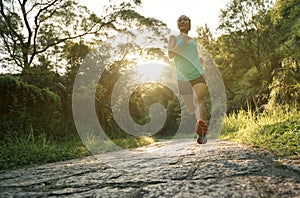 Athlete running on sunrise forest trail