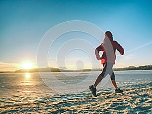 Athlete running woman runner jogging on winter beach