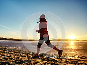 Athlete running woman runner jogging on winter beach