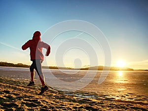 Athlete running woman runner jogging on winter beach