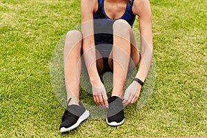 Athlete, shoes and hands for woman runner, laces and nature for cardio exercise. Legs, footwear and sports outdoors or
