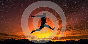 Athlete silhouette jumping happily at sunset with sun