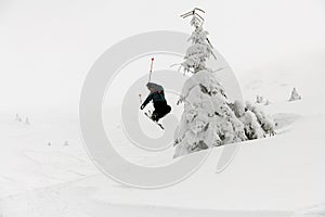 athlete skier masterfully jumping over slopes of snow-capped mountains. Ski touring, freeride extreme sport