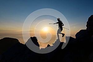 Athlete skyrunner in silhouette on the downhill rocks