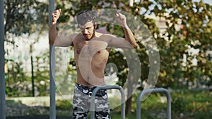 The athlete on the sports ground warms up before training. Muscular man goes in for sports in the open air. The guy in