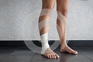 Athlete standing with an ankle tape job on their injured ankle