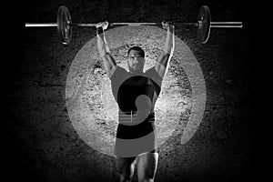 The athlete is standing with a barbell above his head.