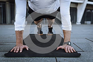 Athlete standing in plank pose, training outdoors