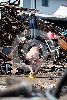 Athlete Standing on Yellow Helmet in Junkyard