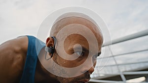 Athlete, start and race with focus for fitness, success and training outdoor with earphones for music. Black man, runner