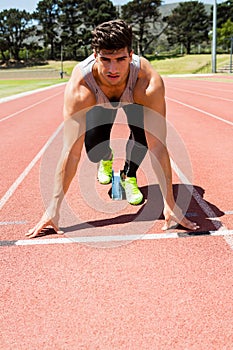 Athlete on a starting block about to run