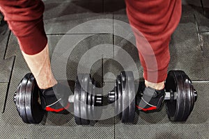 Athlete taking dumbbells from floor, man pov photo