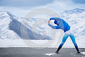 Athlete at the top of the mountain doing stretching