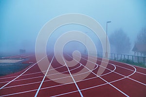 Atletická dráha nebo běžecká dráha s modrým zamlženým pozadím