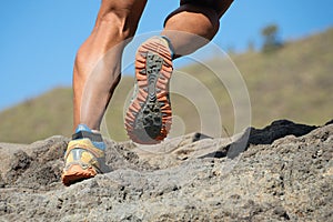 Athlete trail running in the mountains on rocky terrain