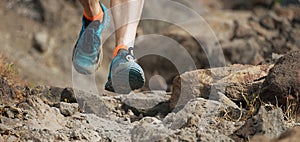 Athlete trail running in the mountains on rocky terrain