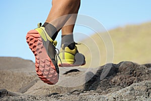 Athlete trail running in the mountains on rocky terrain