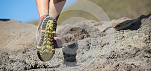 Athlete trail running in the mountains on rocky terrain