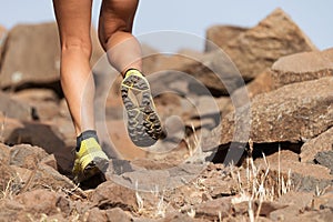 Athlete trail running in the mountains on rocky terrain