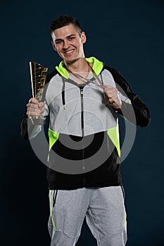 An athlete with a trophy in hand for winning first place in an event.