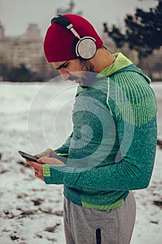 Athlete using mobile phone while listening music outdoor