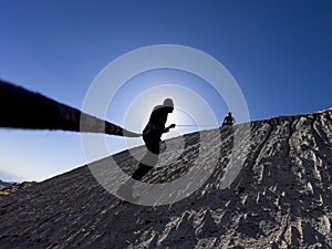 Athlete waiting for his friend at the top while climbing with a rope