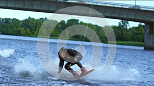 Athlete wakeboarder jumping high above water. Extreme stunt over water