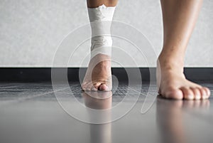 Athlete walking forward with an ankle injury and ankle tape job