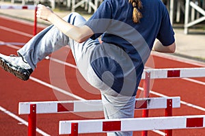 Athlete walking over hurdles to warm up before a race